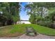 Lush backyard leading to the lake, framed by bamboo and verdant trees, enhancing the property's natural appeal at 8903 Donna Lu Dr, Odessa, FL 33556