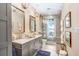 Elegant bathroom featuring double vanity, stylish mirrors, glass-enclosed shower and scenic outdoor views at 8903 Donna Lu Dr, Odessa, FL 33556