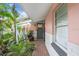 Charming front porch with brick flooring, surfboard accents, and lush landscaping at 8903 Donna Lu Dr, Odessa, FL 33556