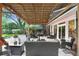 Inviting outdoor living area under a tiki hut roof, furnished with comfortable seating for relaxing and entertaining at 8903 Donna Lu Dr, Odessa, FL 33556