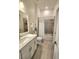 Modern bathroom with double vanity, tiled shower, and ample lighting at 9024 Barrier Coast Trl, Parrish, FL 34219