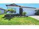 Charming home featuring a beautifully landscaped yard with palm trees and a well-maintained lawn at 9024 Barrier Coast Trl, Parrish, FL 34219