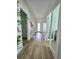 Inviting hallway with sleek wood floors, leading to various rooms within the home at 9024 Barrier Coast Trl, Parrish, FL 34219