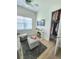 Comfortable living room with a sofa, ottoman, mounted TV, window, and walk-in closet at 9024 Barrier Coast Trl, Parrish, FL 34219