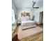 Comfortable primary bedroom with hardwood floors, natural light, and ceiling fan at 9024 Barrier Coast Trl, Parrish, FL 34219