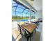 A covered pool area features a dining table, chairs, and comfortable seating area at 9024 Barrier Coast Trl, Parrish, FL 34219
