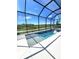A serene pool is surrounded by a screened enclosure and offers a view of the lush landscape at 9024 Barrier Coast Trl, Parrish, FL 34219