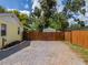 Gravel driveway and wooden fence, leading to a backyard shed at 932 W Wheeler Rd, Brandon, FL 33510