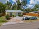 Attractive yellow home with gravel driveway and landscaping, with vibrant blue hydrangeas at 932 W Wheeler Rd, Brandon, FL 33510
