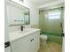 Updated bathroom features a sleek vanity, framed glass shower and retro green tub at 621 Gran Kaymen Way, Apollo Beach, FL 33572