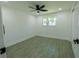 Bright bedroom boasts wood-look tile, ceiling fan, natural light and neutral paint at 621 Gran Kaymen Way, Apollo Beach, FL 33572