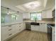 Bright kitchen with white cabinets, stone countertops, undermount sink, stainless steel appliances, and modern lighting at 621 Gran Kaymen Way, Apollo Beach, FL 33572