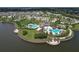 Aerial view of community clubhouse featuring pools, tennis courts, and a lake at 10081 Sage Creek Dr, Sun City Center, FL 33573