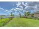 Scenic backyard features lush green lawn, landscaping, and serene lake views at 10081 Sage Creek Dr, Sun City Center, FL 33573