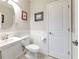 Charming half-bath features pedestal sink, beadboard paneling, and neutral color palette at 10081 Sage Creek Dr, Sun City Center, FL 33573