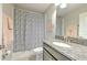 Well-lit bathroom with granite countertop, patterned shower curtain, and modern fixtures at 10081 Sage Creek Dr, Sun City Center, FL 33573