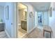Hallway view with a bathroom, lovely rug, bench, and light-filled rooms at 10081 Sage Creek Dr, Sun City Center, FL 33573