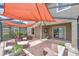 Covered patio with comfortable wicker furniture, an orange shade, and sliding door access at 10081 Sage Creek Dr, Sun City Center, FL 33573