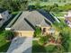 Gorgeous aerial view of a home with a large roof, lush landscaping, and a three-car garage at 10513 Palm Cove Ave, Tampa, FL 33647