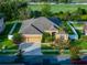 Stunning aerial view of a well-maintained home with lush landscaping, a three-car garage, and a spacious backyard at 10513 Palm Cove Ave, Tampa, FL 33647