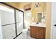 Well-lit bathroom with glass-enclosed shower, decorative curtains and dark brown vanity at 10513 Palm Cove Ave, Tampa, FL 33647