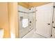 Bathroom features a glass shower with decorative tile and a built-in niche, next to the door at 10513 Palm Cove Ave, Tampa, FL 33647