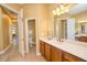 Bathroom with wood cabinets, white countertops, tile flooring, and a doorway to the toilet at 10513 Palm Cove Ave, Tampa, FL 33647