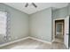 Bedroom with light-filled window, gray walls, wood floors, and doorway leading to bathroom at 10513 Palm Cove Ave, Tampa, FL 33647
