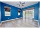 Blue bedroom with sliding glass door, ceiling fan, and modern hardwood floors at 10513 Palm Cove Ave, Tampa, FL 33647