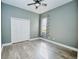 Light-filled bedroom boasts gray walls, wood floors, ceiling fan, and double door closet at 10513 Palm Cove Ave, Tampa, FL 33647