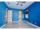Bright blue bedroom featuring modern hardwood floors, ceiling fan, and one window at 10513 Palm Cove Ave, Tampa, FL 33647