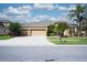 Inviting single-story home with a three-car garage, a well-manicured lawn, and lush landscaping at 10513 Palm Cove Ave, Tampa, FL 33647