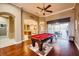 Large game room featuring a billiard table, hardwood floors, and access to outdoor entertainment at 10513 Palm Cove Ave, Tampa, FL 33647