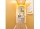 Hallway with hardwood floors leading to bedroom with tray ceilings and fan at 10513 Palm Cove Ave, Tampa, FL 33647