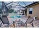 Beautiful screened-in pool area with two lounge chairs, perfect for relaxing and enjoying the outdoors at 10513 Palm Cove Ave, Tampa, FL 33647