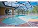 A luxurious screened-in pool area featuring a beautiful pool with a spa and ample patio space at 10513 Palm Cove Ave, Tampa, FL 33647