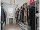 Walk-in closet with rows of hanging clothes, drawers, shelves, and a desk area near the window at 10823 Trailing Vine Dr, Tampa, FL 33610