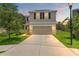 Charming two-story home at dusk with a well-maintained lawn and a two-car garage at 10823 Trailing Vine Dr, Tampa, FL 33610