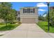 Two-story home with a two-car garage, neutral paint, dark shutters, and well-maintained lawn and landscaping at 10823 Trailing Vine Dr, Tampa, FL 33610