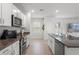 Updated kitchen with stainless appliances, granite counters, and modern lighting at 10823 Trailing Vine Dr, Tampa, FL 33610