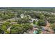 Aerial view of a home with a swimming pool, mature trees, and a pond nearby at 10902 Bent Tree Pl, Tampa, FL 33618