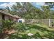 Spacious backyard with a grassy area, stepping stones, mature trees, and fenced perimeter at 10902 Bent Tree Pl, Tampa, FL 33618