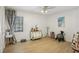 Bright bedroom with wood-look floors, ceiling fan, and a large window providing natural light at 10902 Bent Tree Pl, Tampa, FL 33618