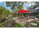 Backyard fire pit with seating area and patio, surrounded by greenery and a screened pool area at 10902 Bent Tree Pl, Tampa, FL 33618