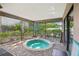 Enclosed outdoor patio featuring a hot tub surrounded by brick pavers and lush greenery at 10902 Bent Tree Pl, Tampa, FL 33618