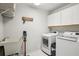 Functional laundry room equipped with modern washer, dryer, sink, and storage cabinets at 10902 Bent Tree Pl, Tampa, FL 33618