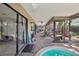 Enclosed patio with a hot tub, brick pavers, and sliding glass doors to the home's interior at 10902 Bent Tree Pl, Tampa, FL 33618