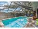 Sparkling in-ground pool with clear blue water, screened enclosure, and patio seating at 10902 Bent Tree Pl, Tampa, FL 33618