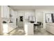 Bright kitchen with white cabinets, stainless appliances, and an island with barstool seating at 11740 E 71St Ave, Palmetto, FL 34221