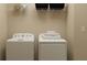 Functional laundry room with white washer, dryer, storage shelf, and neutral walls at 11740 E 71St Ave, Palmetto, FL 34221